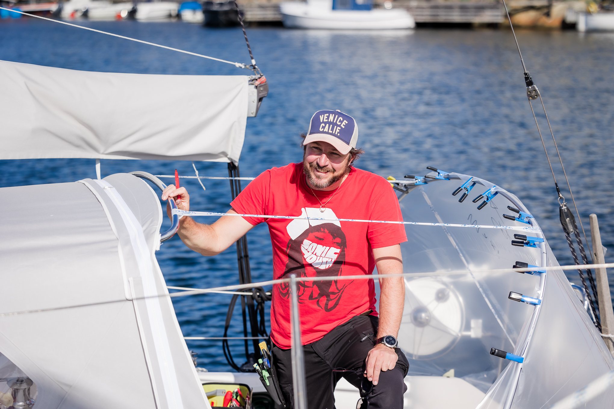 En leende kapellmakare på en segelbåt